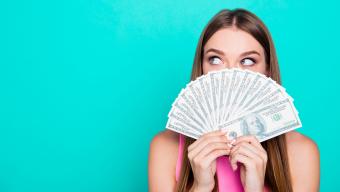 woman holding money in front of her face